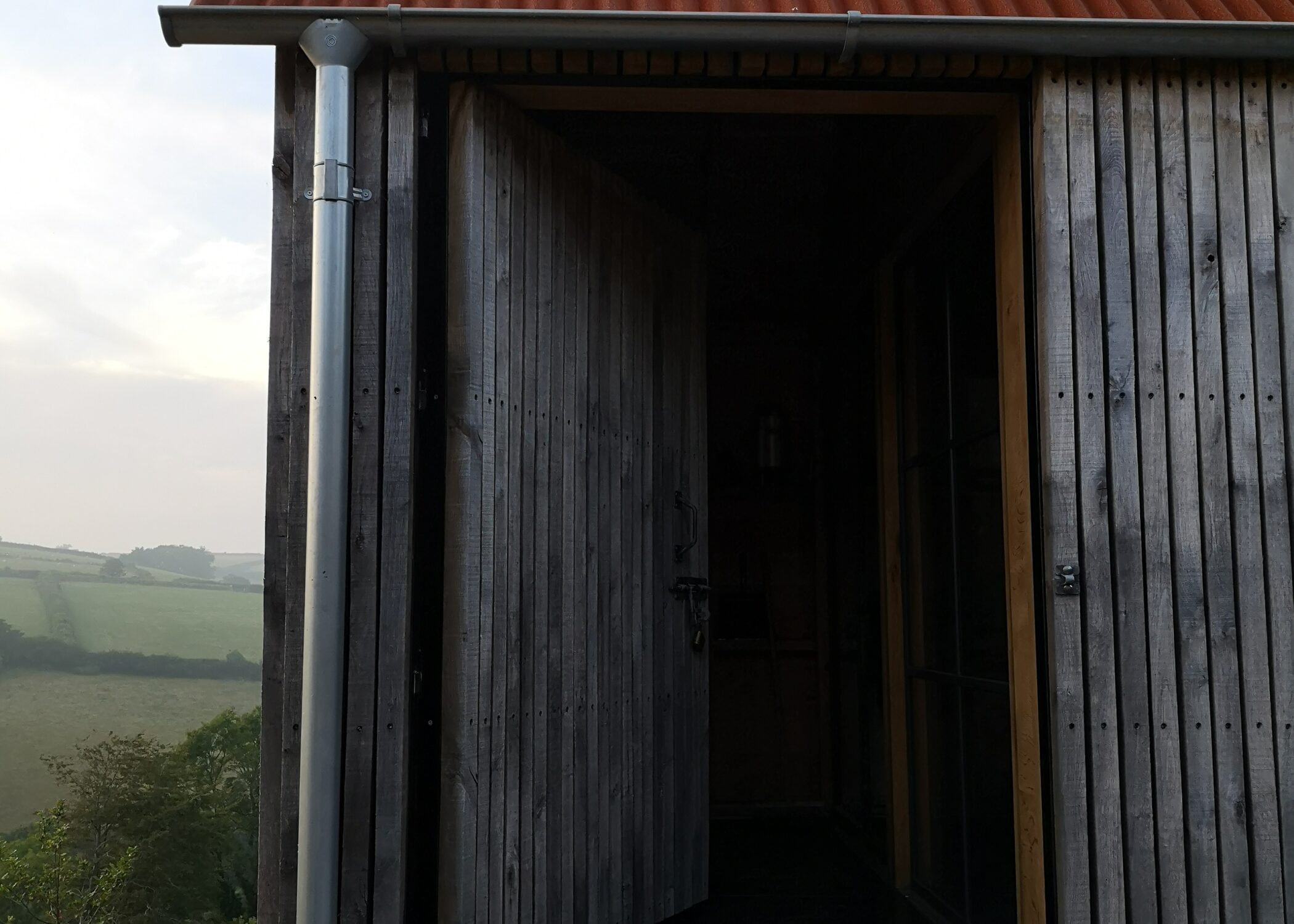 Woodcutters Reguge with vertical timber cladding, galvinised Lindab guttering and a Corten sheet roof