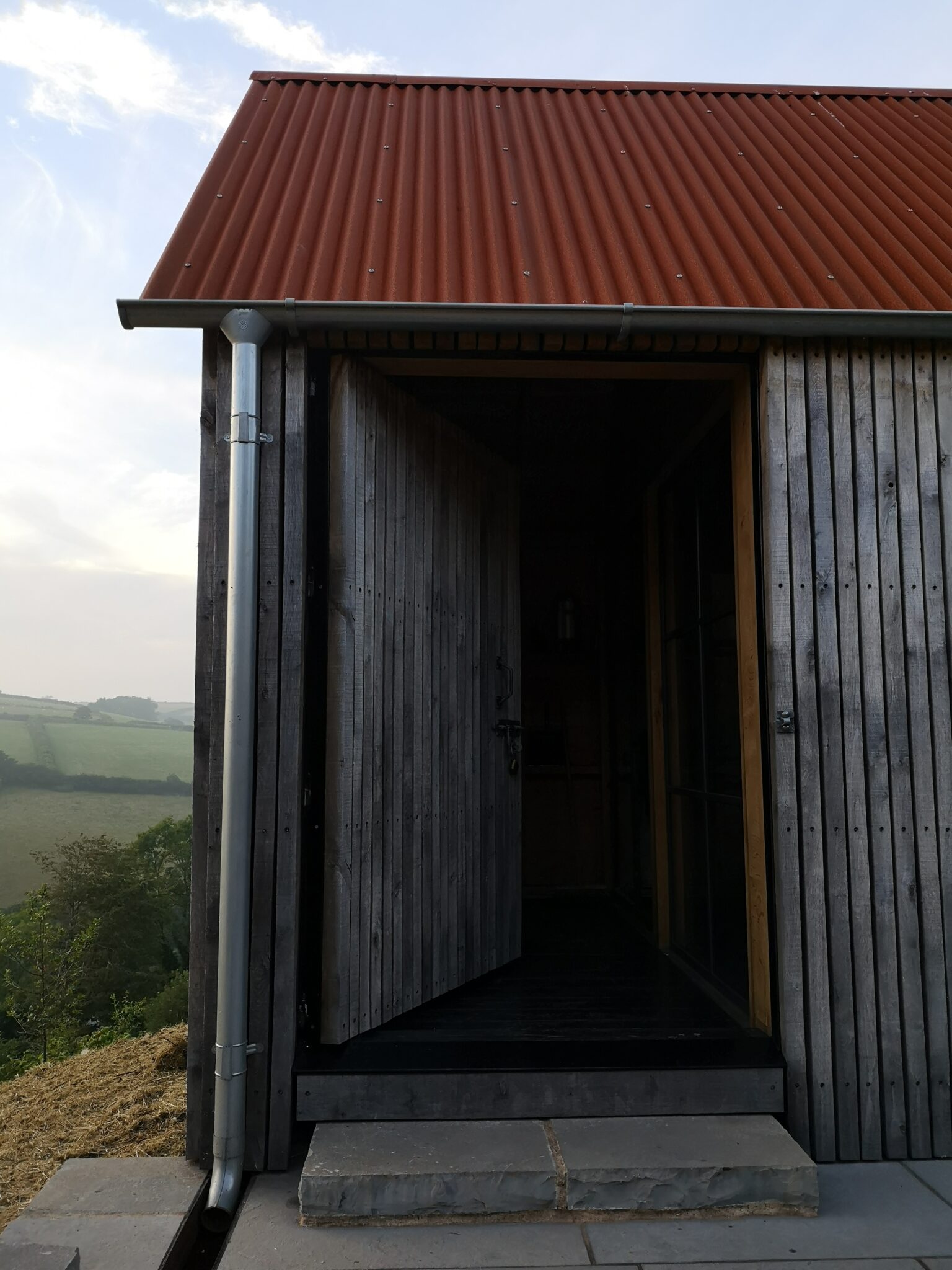 Woodcutters Reguge with vertical timber cladding, galvinised Lindab guttering and a Corten sheet roof